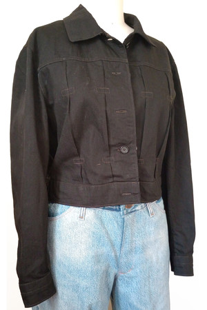 Front view of jean jacket in black twill with 5 button front and pleats